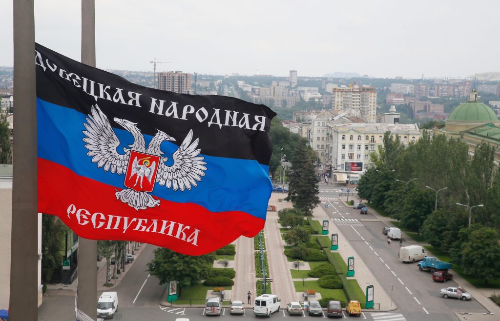 <em>The flag of the self-proclaimed Donetsk People Republic is flying over the city of Donetsk. The flag bears the emblem of Russia: two-headed eagle.</em>