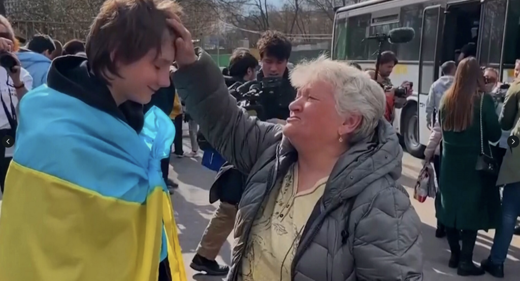 A teenage boy wrapped in the Ukrainian flag was one of the 31 Ukrainian children brought back to Ukraine by the Save Ukraine charity after they had been forcibly taken to Russia.